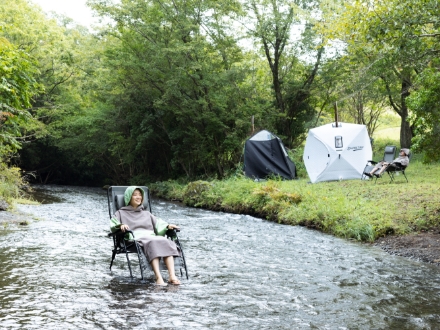川辺のテントサウナを楽しむ男性と女性の写真