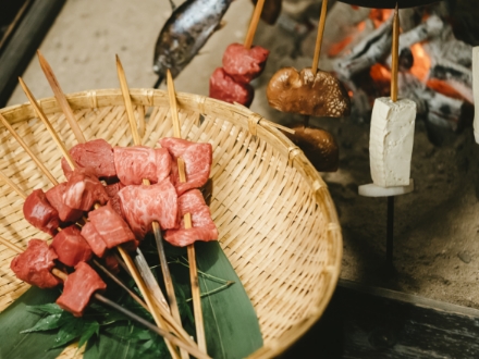 串に刺されている赤牛肉の写真